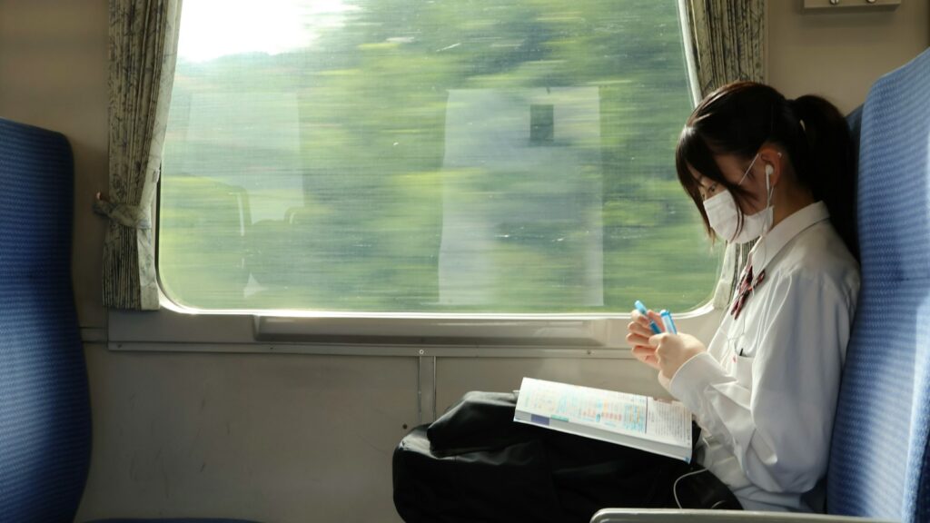 A woman sitting on a train reading a book for neet pg 2025 exam